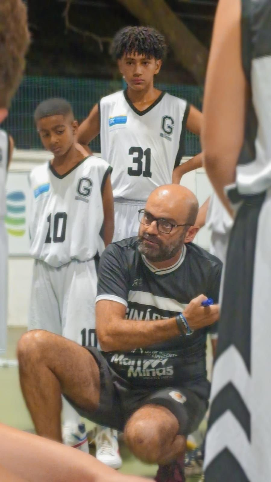 Foto de professor da Escola de Basquete do Esporte Clube Ginástico apresentando sua estratégia.