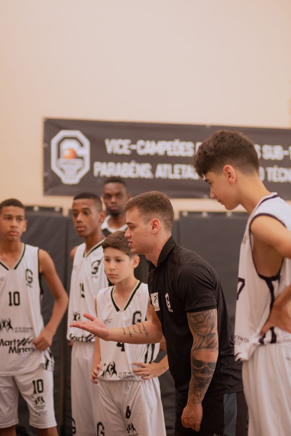 Professor apresentando uma estratégia para jovens na Escola de Basquete