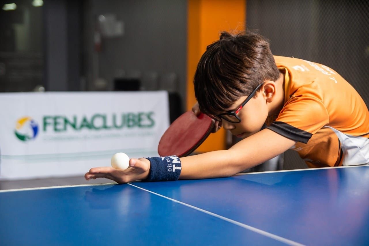 Jovem se preparando para jogar Tênis de mesa